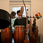 Mann sitzt hinter großen Trommeln